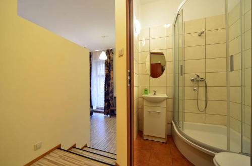 Apartaments Piotrkowska 101 في لودز: حمام مع حوض ومغسلة ودش