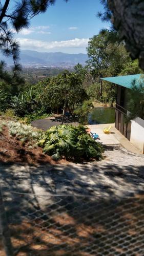 a view of a house with a pool and trees at Hotel Monte Campana Heredia in Birrí