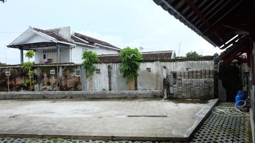 a house with a fence and a courtyard at Omah Dronjongan Homestay Yogyakarta in Yogyakarta