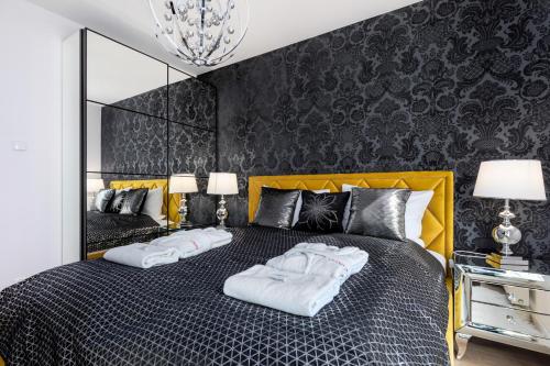 ein Schlafzimmer mit einem gelben Bett mit zwei Handtüchern darauf in der Unterkunft Seaside Terraces Deluxe Apartments by Renters Prestige in Kołobrzeg