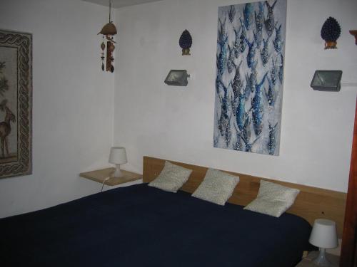 una camera con letto blu e 2 cuscini di Appartamento Vivaldi a Mondello