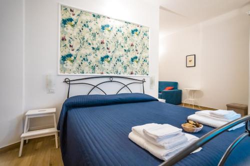 a bedroom with a blue bed with towels on it at Valle dei Mulini - Appartamenti in Bellano