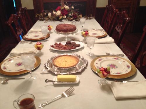 una mesa con un pastel y comida en ella en Adair Manor Bed & Breakfast, en Adairsville