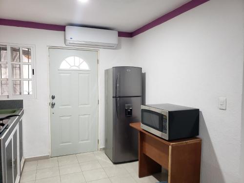 a kitchen with a refrigerator and a microwave at Casa Zac Nicte Mx-Estudio SISAL in Cancún