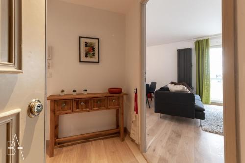 un couloir avec une chambre dotée d'une table et d'une chaise dans l'établissement L’Esperluette - 44 sqm apartment with garage & balcony in the city center, à Annecy
