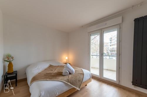 une chambre blanche avec un lit et une fenêtre dans l'établissement L’Esperluette - 44 sqm apartment with garage & balcony in the city center, à Annecy