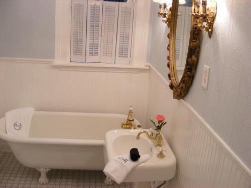 y baño con bañera y lavamanos. en Adair Manor Bed & Breakfast, en Adairsville