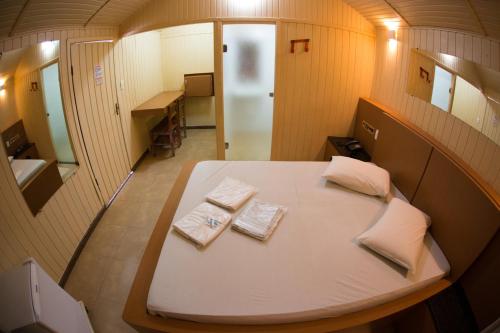 ein kleines Zimmer mit einem Bett und zwei Handtüchern in der Unterkunft Chale Motel in Paulínia