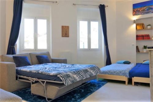 a bedroom with a bed and a couch and windows at BIG Flat - 2 FREE Parking - Virtual Visit ! in Nice
