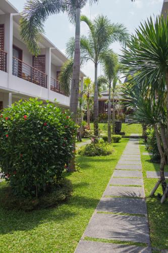 a walkway in front of a resort with palm trees at Pertiwi Bisma 1 in Ubud