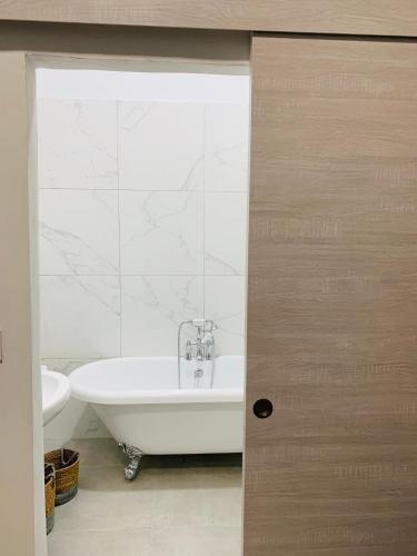 une salle de bain avec une baignoire blanche et un lavabo dans l'établissement LE 31, à Carcassonne