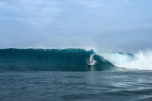 a man riding a wave on a surfboard in the ocean at Bito's GH in Himmafushi