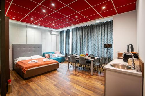 a bedroom with a bed and a table and a kitchen at Oxford Apartments in Ljubljana