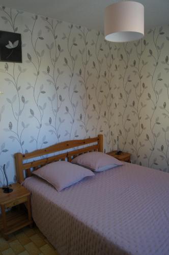 - une chambre avec un lit et un mur recouvert de papier peint dans l'établissement Lara 4 - T2 spacieux Parking - Près centre-port, île des Loisirs, plage Richelieu, au Cap d'Agde