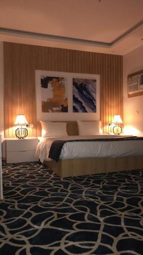 a bedroom with a large bed with two lamps at Juri Ahla Al Masayef Furnished Units in Taif