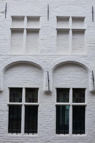 three windows on the side of a white building at Nonam Boutique Hotel Gent in Ghent