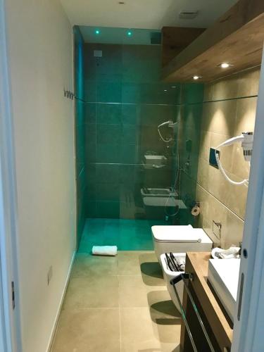 a bathroom with a shower and a sink and a toilet at White Bay in Fontane Bianche