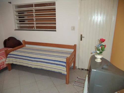 a room with a bed and a tv and a window at Jóias Preciosas- Kitnet Mobiliado in Campinas
