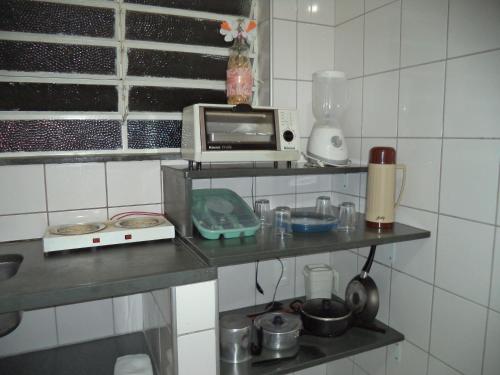 a kitchen with a counter top with a microwave at Jóias Preciosas- Kitnet Mobiliado in Campinas