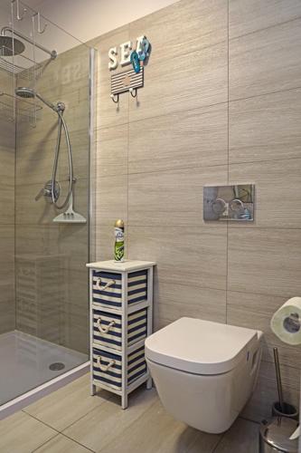 a bathroom with a toilet and a shower at Apartament BLUE BAY Darłówko in Darlowko