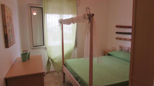 a bedroom with a green bed and a window at FLAMINGO in Lesina