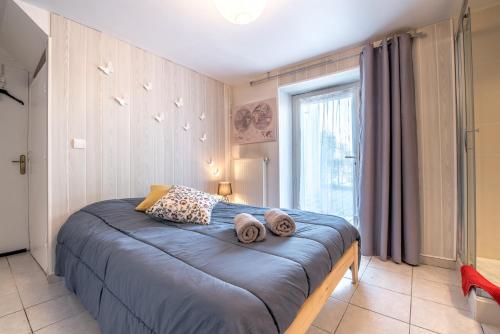 Un dormitorio con una cama azul con toallas. en La Savouè - Chambre en Francin