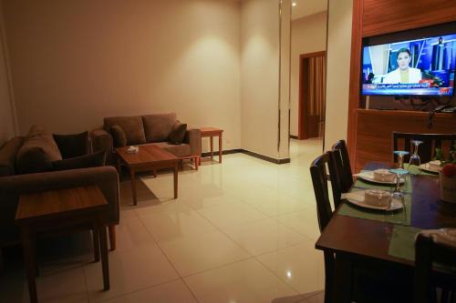 a living room with a couch and a television at Kayan Al Taif Hotel in Taif