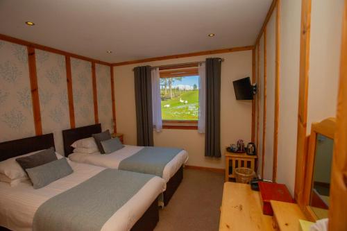 
a bedroom with a bed and a window at Old Pines Hotel And Restaurant in Spean Bridge
