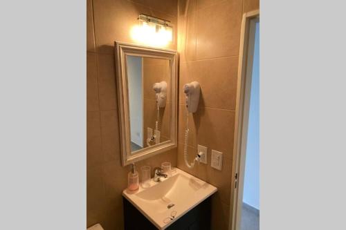 y baño con lavabo y espejo. en Apartamento nuevo en Congreso- amplio- vista inigualable en Buenos Aires