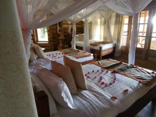 a bedroom with a white bed with flowers on it at Trackers Safari Lodge Bwindi in Buhoma