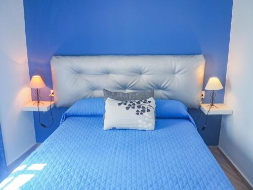 een blauwe slaapkamer met een blauw bed en een wit kussen bij ConilPlus apartment SANTA CATALINA II in Conil de la Frontera