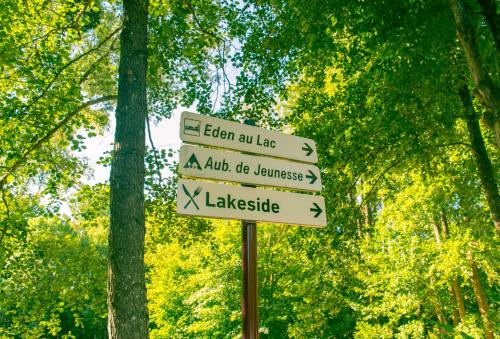 a street sign with arrows on it in a forest at Eden au Lac in Echternach