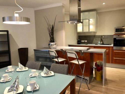 a kitchen with a table with cups and chairs at 2-Zimmer Ferienwohnung im Herzen von Scheeßel in Scheeßel