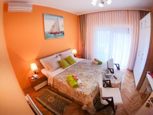 1 dormitorio pequeño con 1 cama, mesa y sillas en Apartments Karmelić, en Malinska