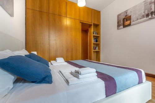 ein weißes Bett mit blauen Kissen und Handtüchern darauf in der Unterkunft Casa da Suite Essenza in Mailand