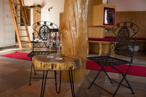 two chairs and a table with wine glasses on it at SECRET WELLNESS in Bodonci