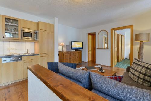 ein Wohnzimmer mit einem Sofa und einem Tisch in der Unterkunft Fürmesli Appartements in Lech am Arlberg