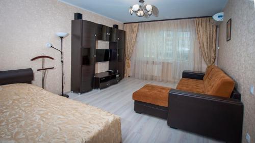 ヴェリーキー・ノヴゴロドにあるApartment Moskvichkaのベッドルーム(ベッド1台、テレビ、ソファ付)