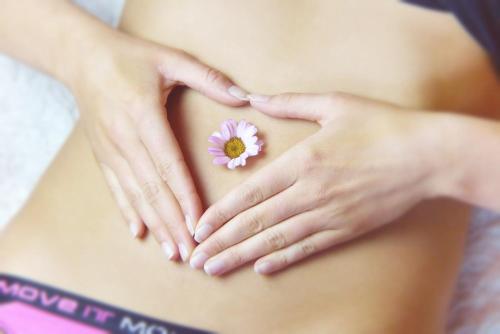 a pregnant woman holding a flower on her stomach at Kurhotel Anders in Bad Füssing