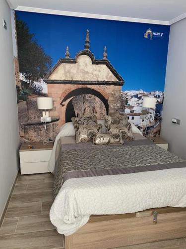 a bedroom with a large bed with a mural on the wall at Apartamento Felipe V in Ronda