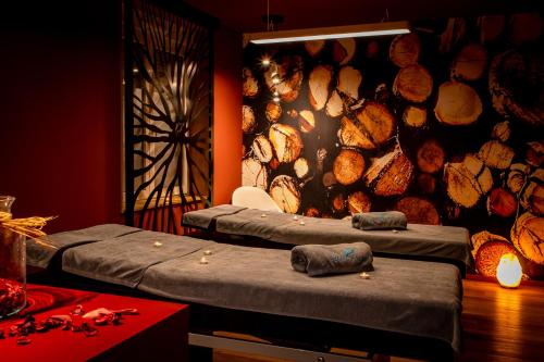 two beds in a room with a wall of logs at L'Orée du Bois in Vittel