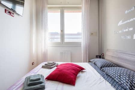 una camera da letto con un letto con un cuscino rosso e una finestra di M2BO DOSSETTI 27 - FIERA a Bologna