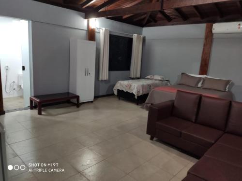 a living room with a bed and a couch at Chalés da Zelma in Capitólio