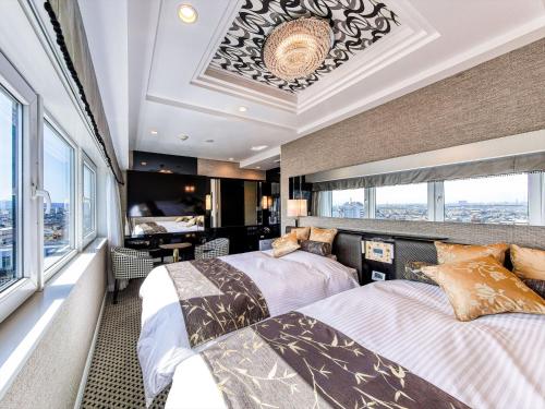 Duas camas num quarto com uma janela em APA Hotel Takaoka Ekimae em Takaoka