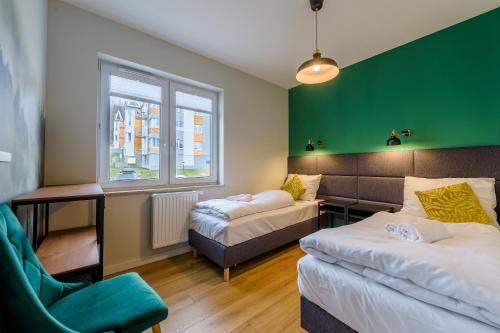 um quarto com duas camas e uma parede verde em Apartament Izerka z Sauną - 5D Apartamenty em Świeradów-Zdrój