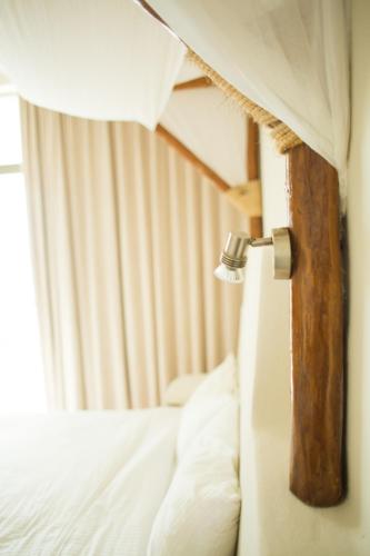 a close up of a bedroom with a bed and a window at Paamul Hotel in Paamul