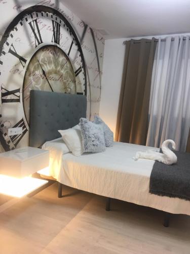 een kamer met een bed met een grote klok aan de muur bij CASA DE TOSCA in Lucena