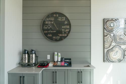 a clock on the wall above a table with a coffee maker at Prestige Vernon Lodge in Vernon