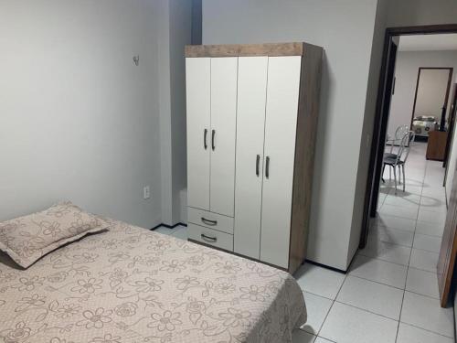 um quarto com uma cama e um armário branco em Pousada Residencial Milagre 101 em Juazeiro do Norte