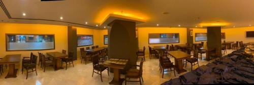 a restaurant with tables and chairs in a room at Doolve Hotel Al Khobar in Al Khobar